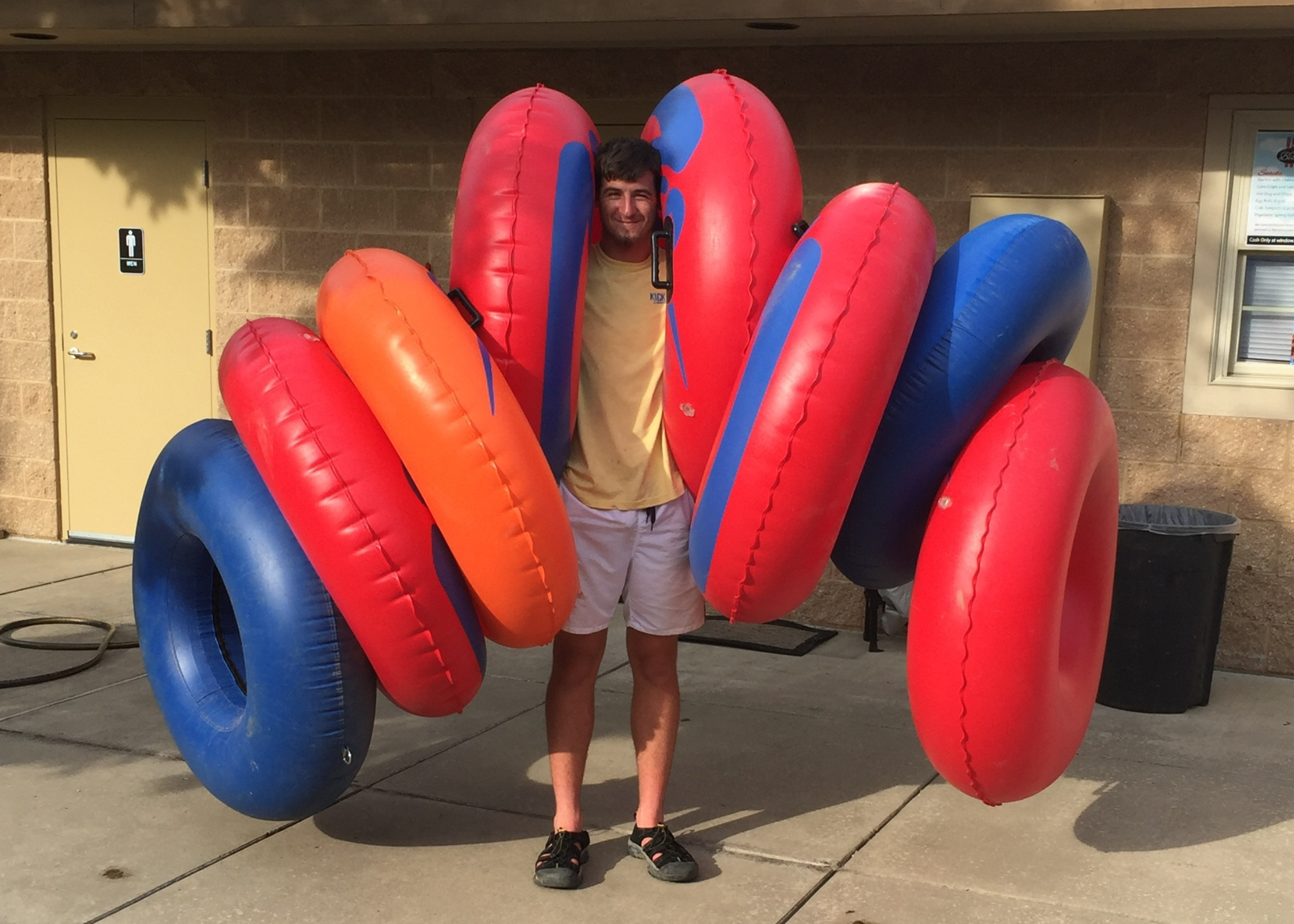 Employee holding tubes on arms at Kickapoo Adventures